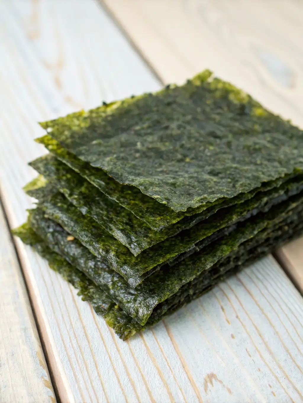 A visually appealing shot of a stack of crispy seaweed snacks with sesame seeds, showcasing their thin and delicate texture against a minimalist background.